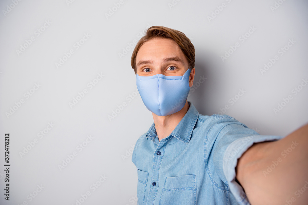 Self-portrait of his he nice healthy attractive guy wearing textile trendy reusable safety blue mask stop influenza wuhan china disease health care immunity isolated over grey color background Self-portrait of his he nice healthy attractive guy wearing textile trendy reusable safety blue mask stop influenza wuhan china disease health care immunity isolated over grey color background