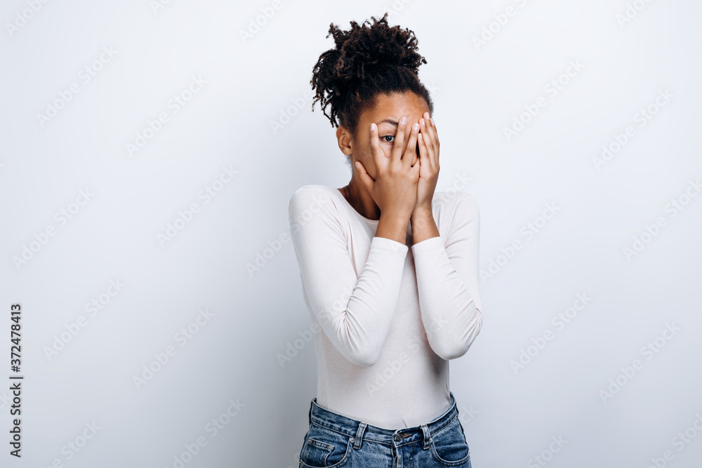 A picture of a terrified woman covering her face over white background A picture of a terrified woman covering her face over white background