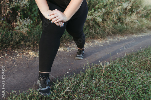 Woman warming up legs before outdoor running. Getting ready for jogging. Sport, activity, healthy lifestyle and weight loss