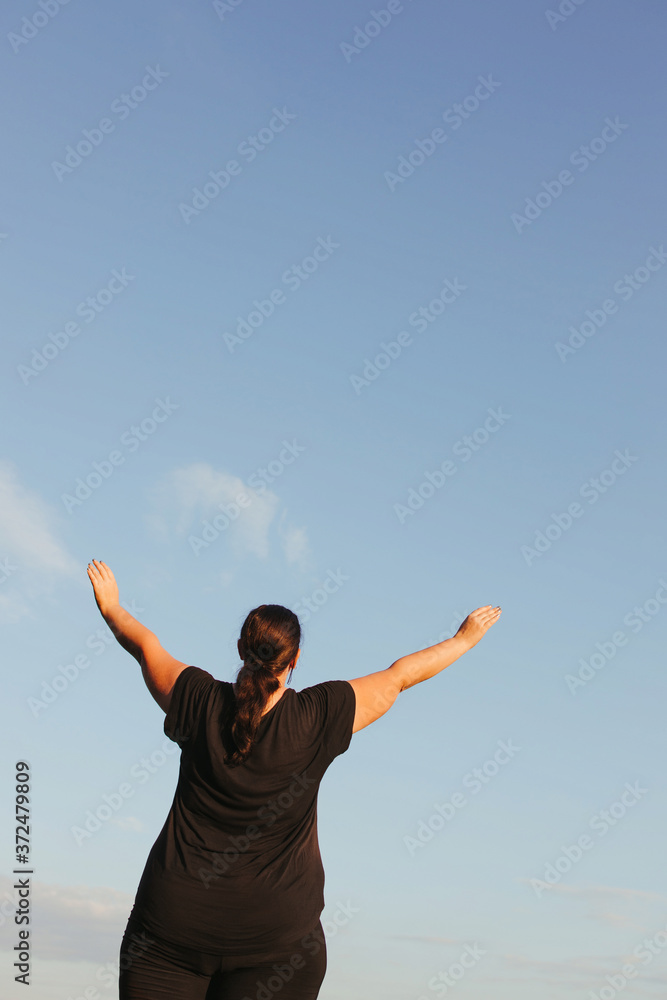 Body positive, freedom, high self esteem, confidence, happiness, inspiration, success, positive affirmation. Overweight woman celebrating rising hands to the sky Body positive, freedom, high self esteem, confidence, happiness, inspiration, success, positive affirmation. Overweight woman celebrating rising hands to the sky