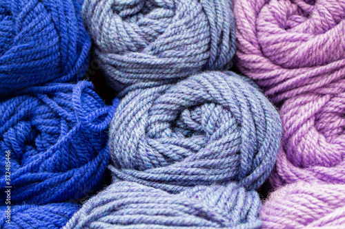 Close-up of skeins of thread in blue, lilac and pink pastel colors. Thread background