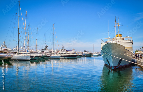 Boats and yachts anchored or moored in Athens marina and by its promenade in Glyfada on a bright summer day. Athens, Greece