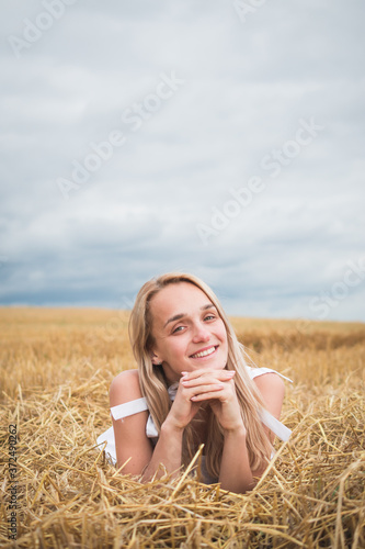 Portrait of bohemian girl with white art posing over wheat field a summer day