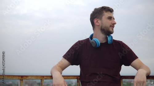 The man takes off his headphones and looks away