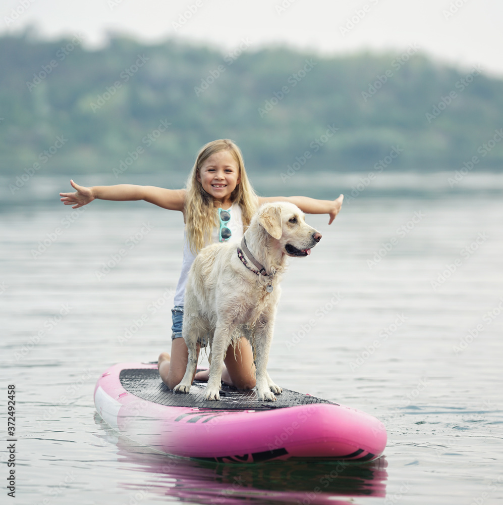 lachendes Kind mit Hund auf dem Board