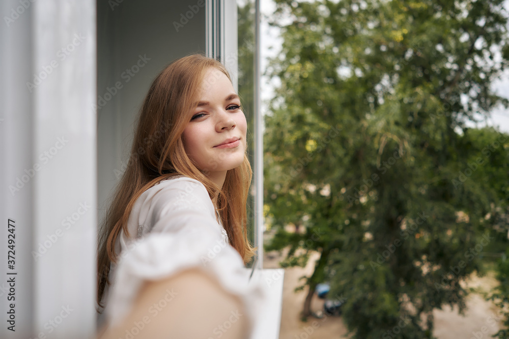 Woman stands on the terrace of the house and takes a selfie Woman stands on the terrace of the house and takes a selfie