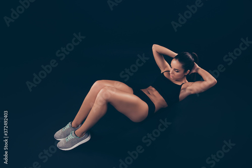 Full length side photo short sport suit lady doing abs workout exercise at fitness club isolated black dark background