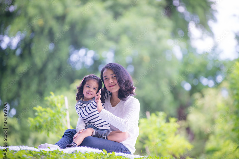 Asian kid are having fun with their mothers in the form of a vacation in the park.Mother's love concept, selective focus Asian kid are having fun with their mothers in the form of a vacation in the park.Mother's love concept, selective focus