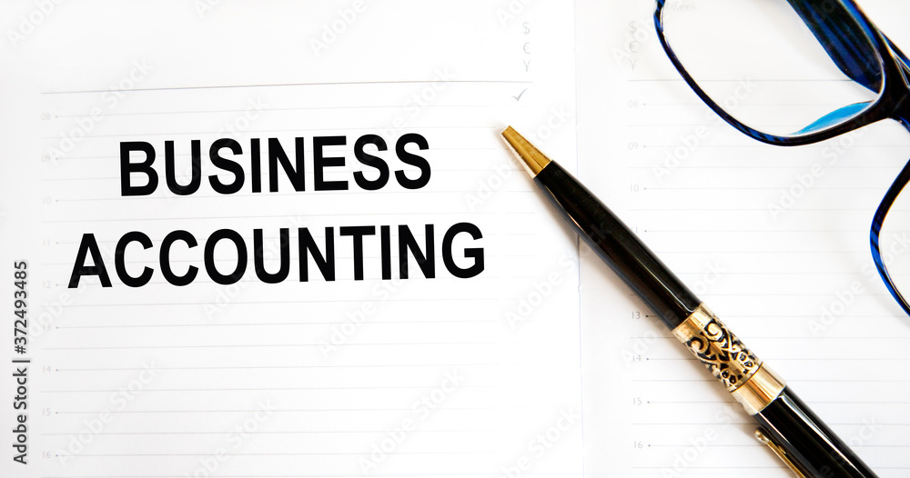 In the notebook the inscription - BUSINESS ACCOUNTING, next to a pen. Finance and business concept. In the notebook the inscription - BUSINESS ACCOUNTING, next to a pen. Finance and business concept.