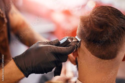 Barber cutting hair of male client