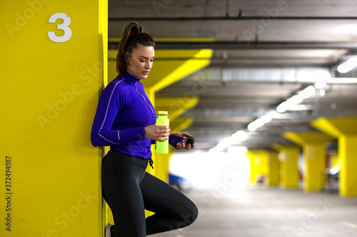 Fit girl in sportswear exercise in public garage to stay fit