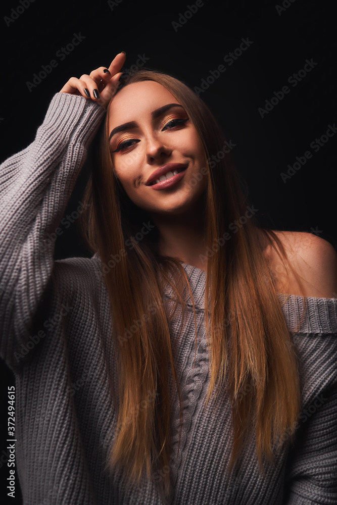portrait of a model in a gray sweater on a black background portrait of a model in a gray sweater on a black background