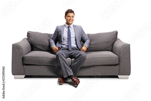 Man in elegant clothes sitting on a sofa and smiling