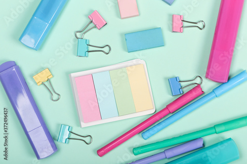 Back to school shopping concept. Pastel colored school supplies on paper background. Flat lay, top view, copy space.