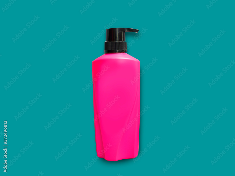 Pink plastic bottle on green background. Cosmetic beauty product branding mock-up. Copy space Pink plastic bottle on green background. Cosmetic beauty product branding mock-up. Copy space
