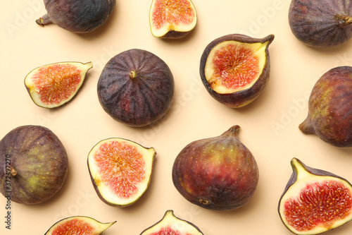 Fresh fig fruits and slices on beige background, top view