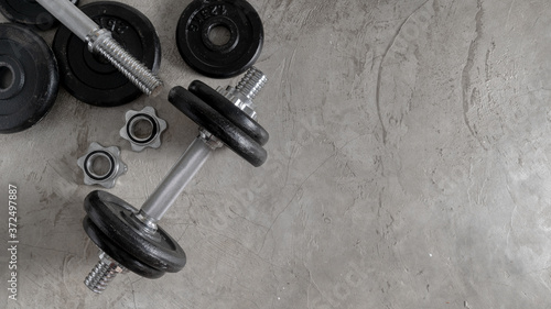 Steel dumbbells on the cement floor in the gym For bodybuilders