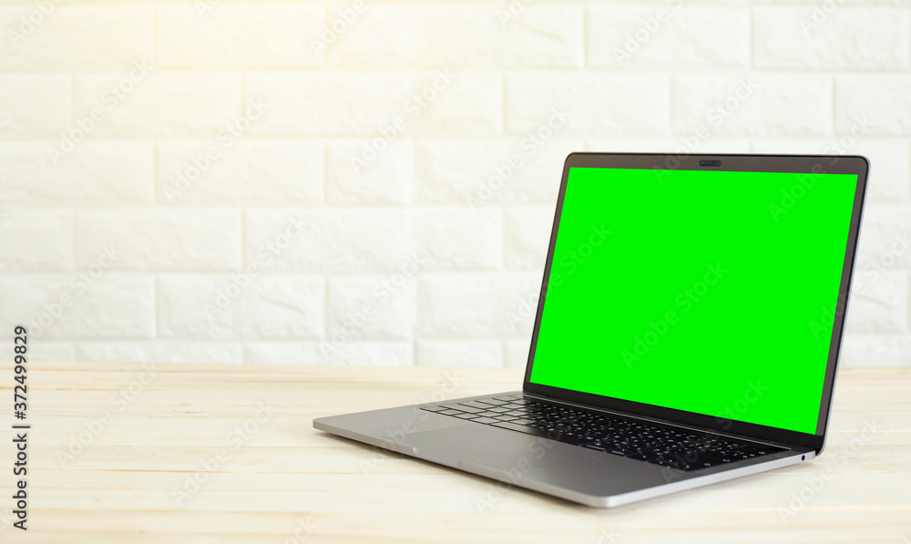 A laptop on a wooden floor and a white wall background. A laptop on a wooden floor and a white wall background.