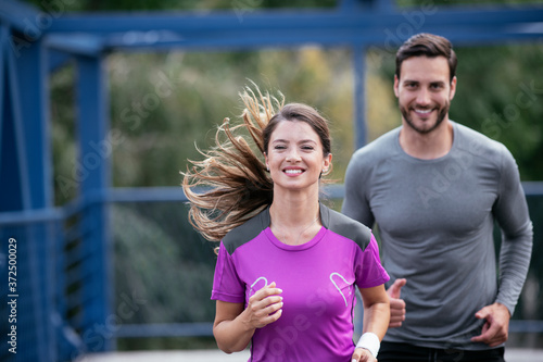 Athletic couple jogging in the city. Happy couple training outdoors.