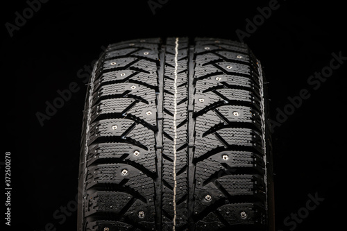new winter studded tire close-up on a black background, front view