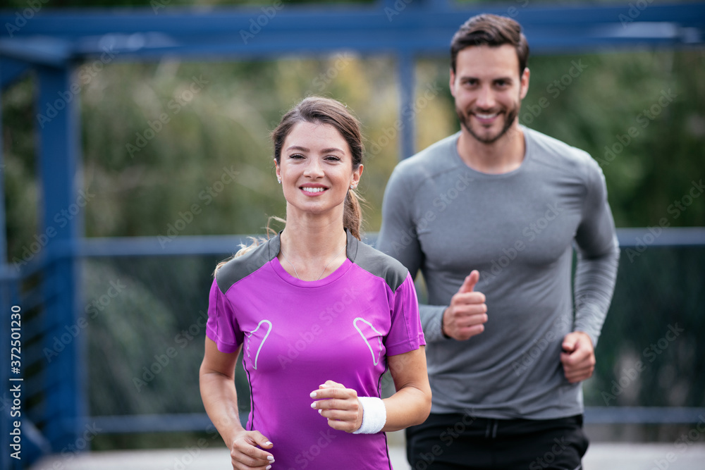 Obraz premium Athletic couple jogging in the city. Happy couple training outdoors.