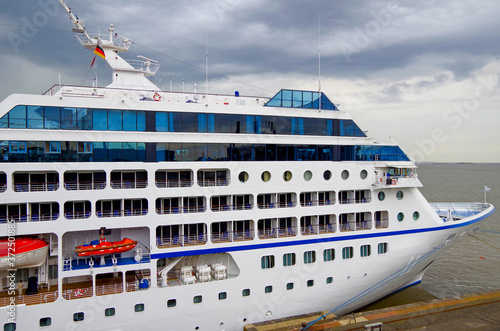 Luxuskreuzfahrtschiff am Kai im Hafen von Bremerhaven - Luxury cruiseship or cruise ship liner at cruise terminal with cargo cranes in Bremerhaven, germany during Baltic cruising photo