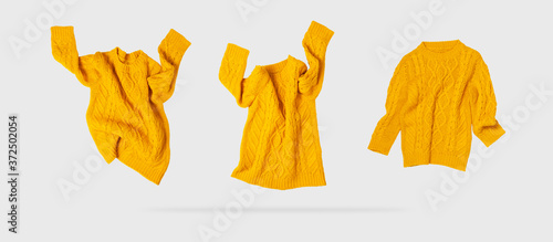 Tableau sur toile Yellow orange flying women's autumn knitted sweater on light gray background