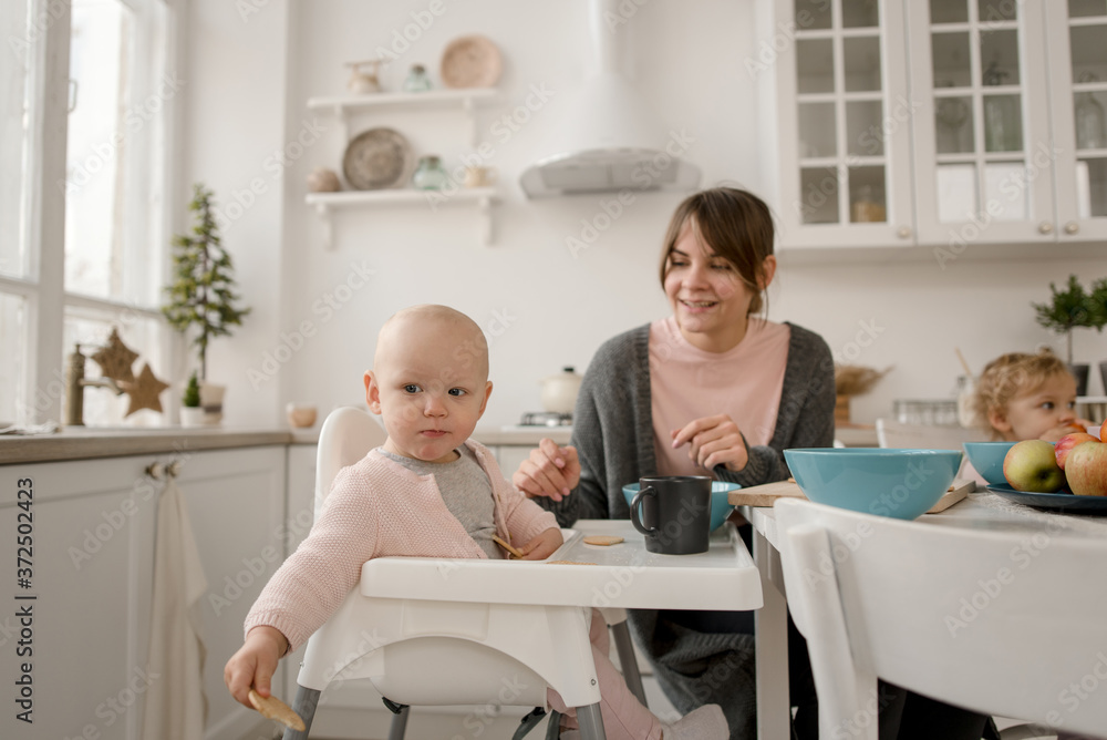 A young mother spends time with her little daughters at home. A young mother spends time with her little daughters at home.