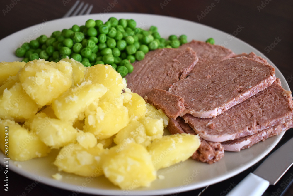 Corned beef with potato and green peas. Selective focus. Corned beef with potato and green peas. Selective focus.