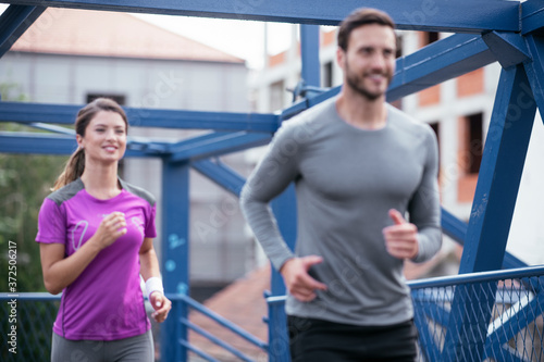 Athletic couple jogging in the city. Happy couple training outdoors.