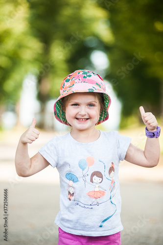 Cheerful girl with positive emotions in a panama hat on a walk