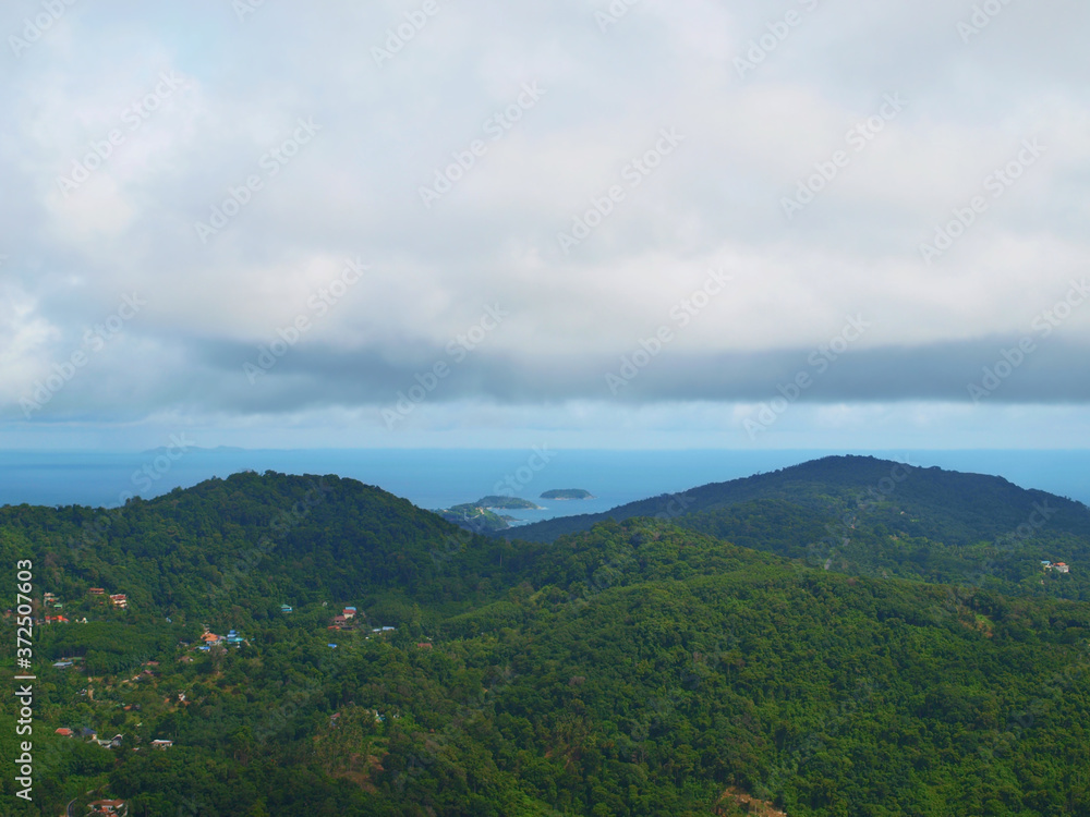 Mountain landscape with clouds. Turquoise sea, a lot of small islands, cloudy sky. Thunderclouds. Two green hills. Panoramic view from the top of green hill. Forest, tropical jungle. Thailand. Phuket