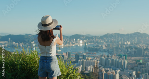 Woman use of cellphone to take photo under sunset © leungchopan