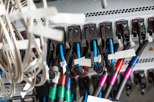 Many multi-colored blue black cables connected to a black load. Horizontal orientation. 