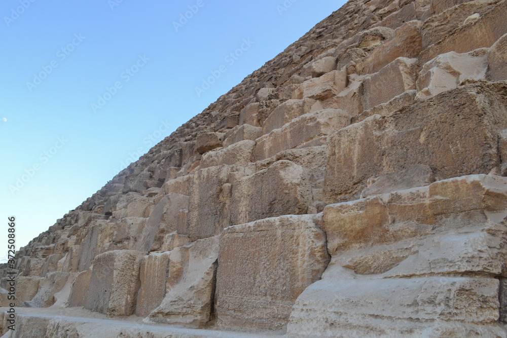 The golden sandstone of the Great Pyramid of Giza, Egypt, and the blue sky The golden sandstone of the Great Pyramid of Giza, Egypt, and the blue sky