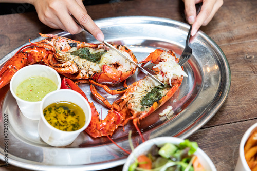 A piece of lobster on a fork in a hand close up