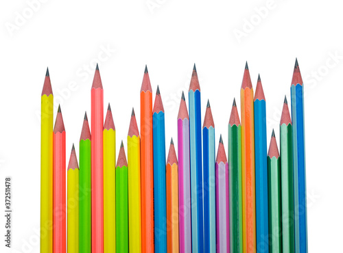 Many different colored wood pencil crayons scattered in a line on a white paper