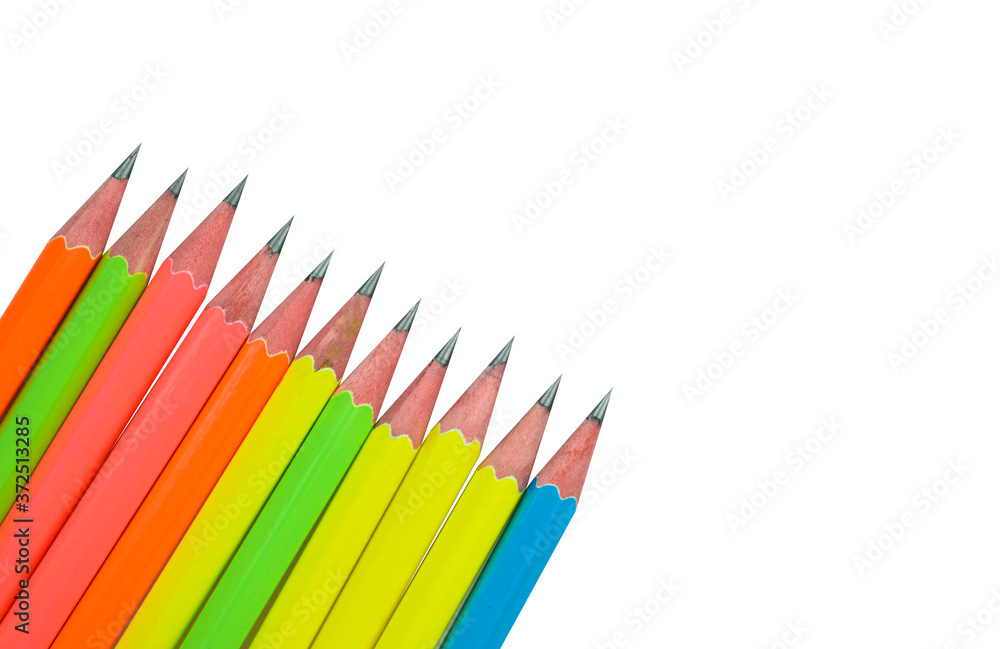 Fototapeta premium A small line of different colored wood pencil crayons placed on a white paper background