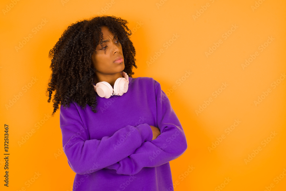 Image of upset pretty young caucasian lady standing indoors with arms crossed. Looking with disappointed expression aside after listening to bad news. Confident girl. Image of upset pretty young caucasian lady standing indoors with arms crossed. Looking with disappointed expression aside after listening to bad news. Confident girl.