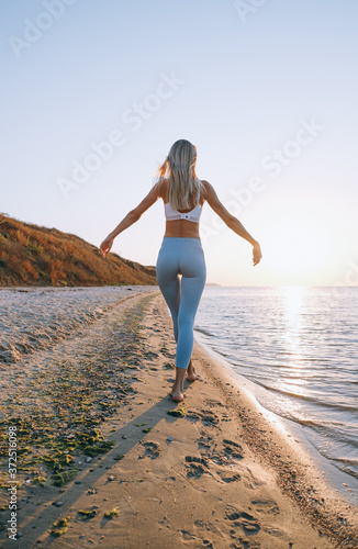 Wallpaper Mural a woman in a tracksuit walks near the sea on the beach Torontodigital.ca