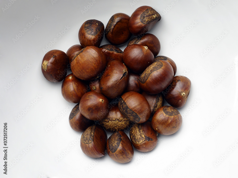 roasted chestnuts on white plate background roasted chestnuts on white plate background