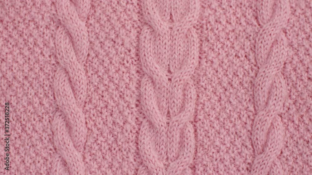 Extreme close up pink wool knitted fabric with scythe pattern. Texture, textile background. Macro shooting, camera slowly moving along the cloth on slider. Extreme close up pink wool knitted fabric with scythe pattern. Texture, textile background. Macro shooting, camera slowly moving along the cloth on slider.