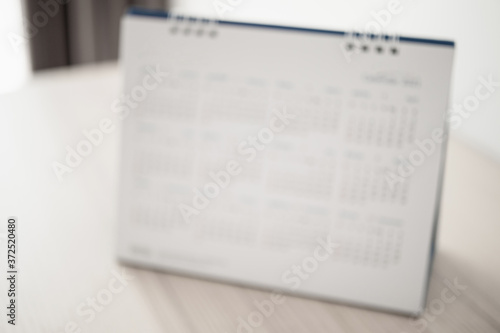 Blur calendar page close up on wood table background business planning appointment meeting concept