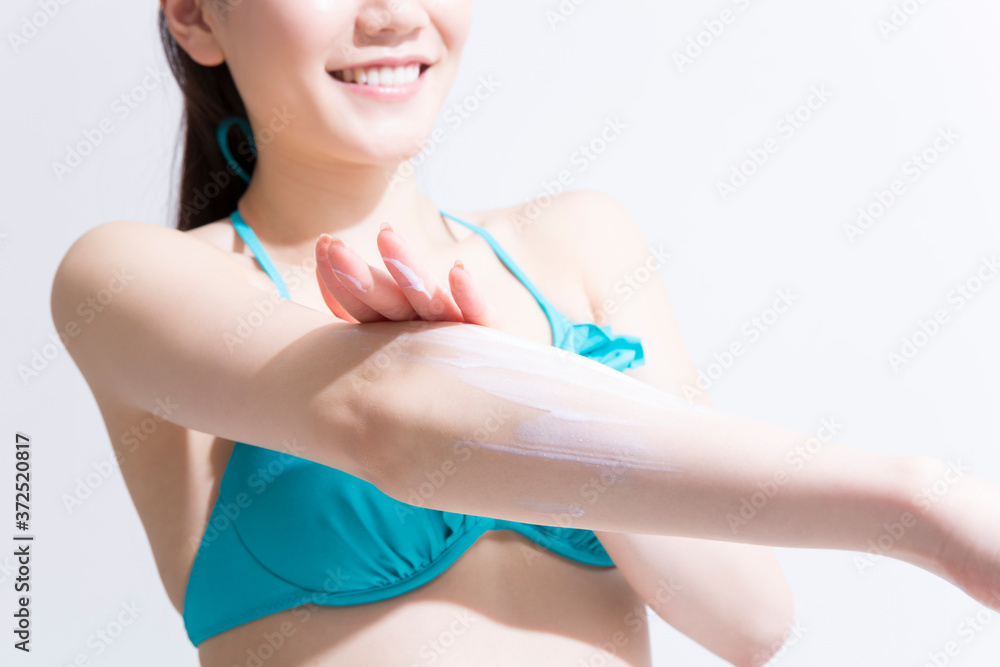 日焼け止めを塗る水着姿の女性 日焼け止めを塗る水着姿の女性
