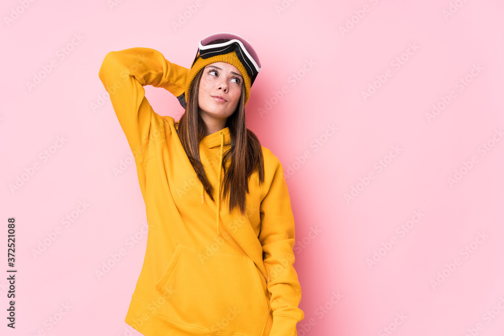 Fototapeta premium Young caucasian skier woman isolated touching back of head, thinking and making a choice.