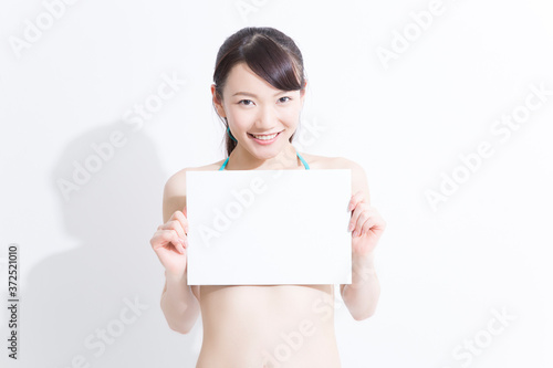 メッセージボードを持つ水着姿の女性