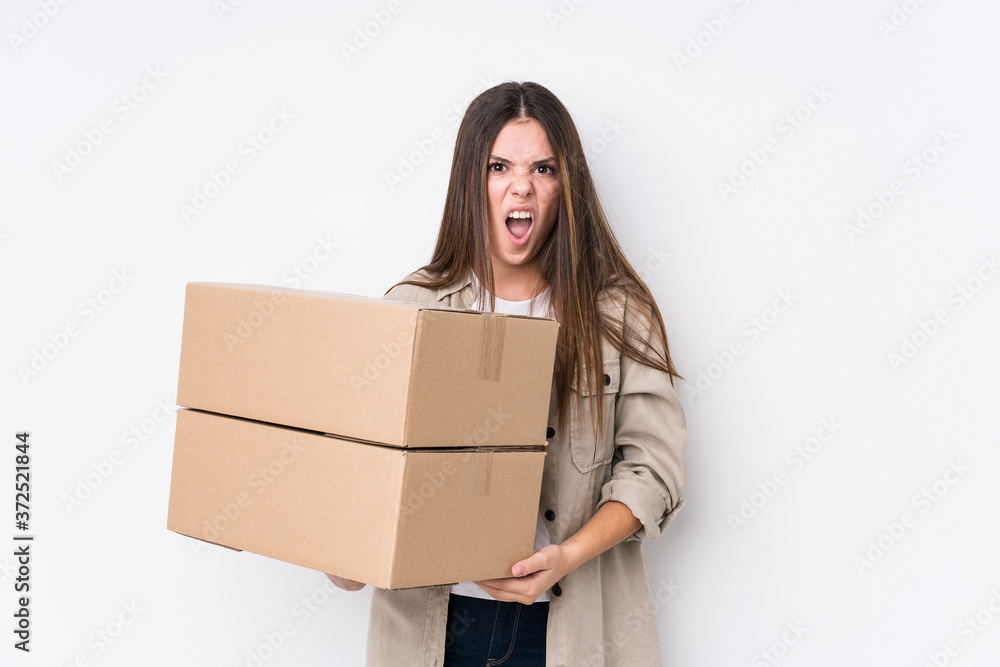 Young caucasian woman moving to a new home screaming very angry and aggressive. Young caucasian woman moving to a new home screaming very angry and aggressive.