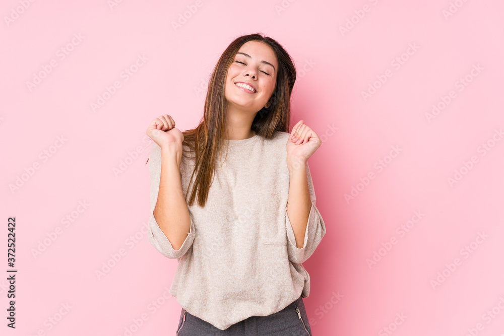 Young caucasian woman posing isolated raising fist, feeling happy and successful. Victory concept. Young caucasian woman posing isolated raising fist, feeling happy and successful. Victory concept.