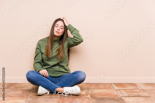 Young caucasian woman sitting on the floor isolated being shocked, she has remembered important meeting.