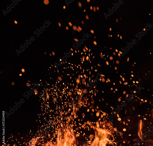 Fototapeta fire flames with sparks on a black background, close-up